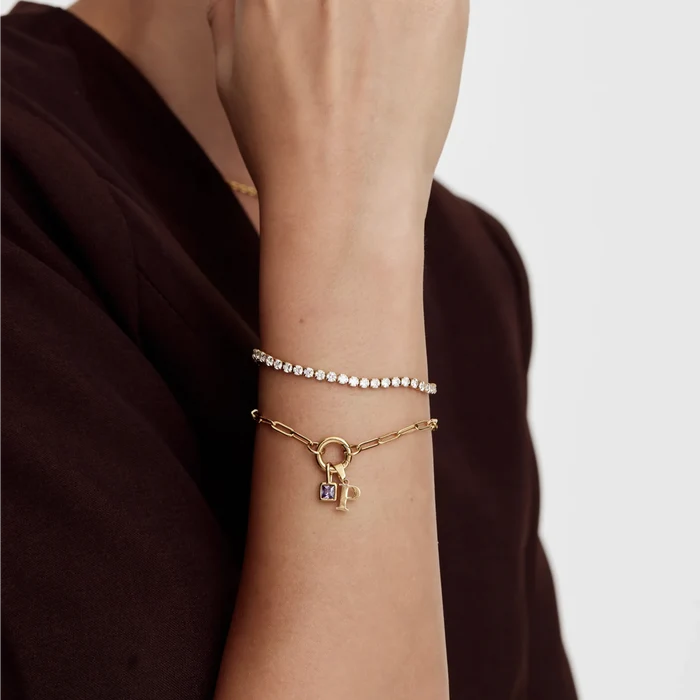 Paperclip Initial Birthstone Bracelet with letter P worn layered with tennis bracelet on wrist
