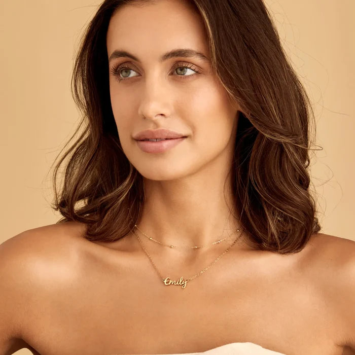 Gold signature name necklace worn on model — Olivia Jewelry