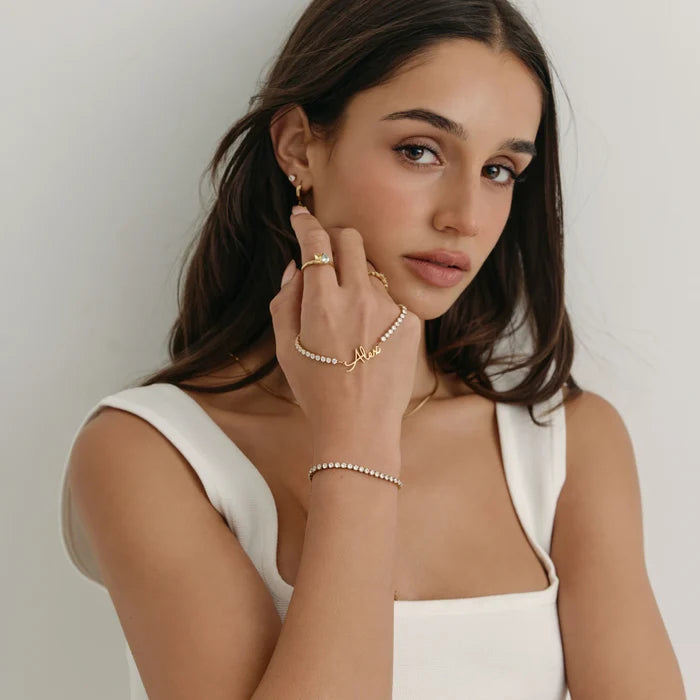 Signature Name Tennis Bracelet personalised as Alex worn on model's wrist in gold